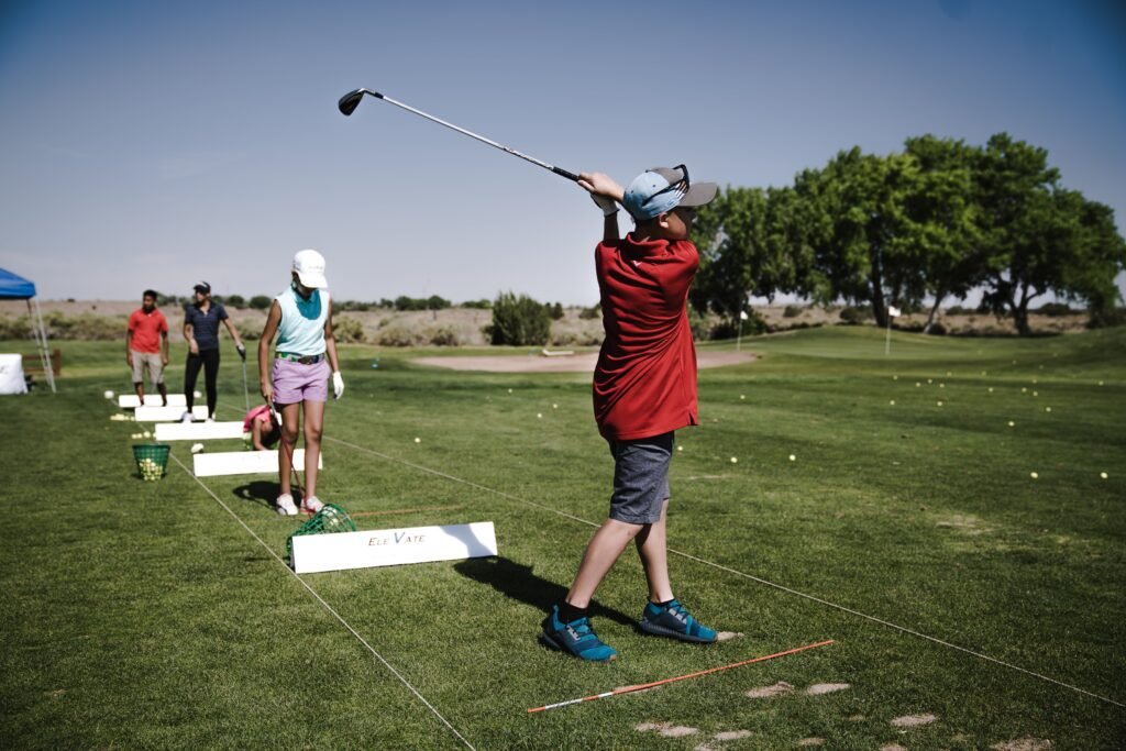 Person Swinging Golf Club on Field